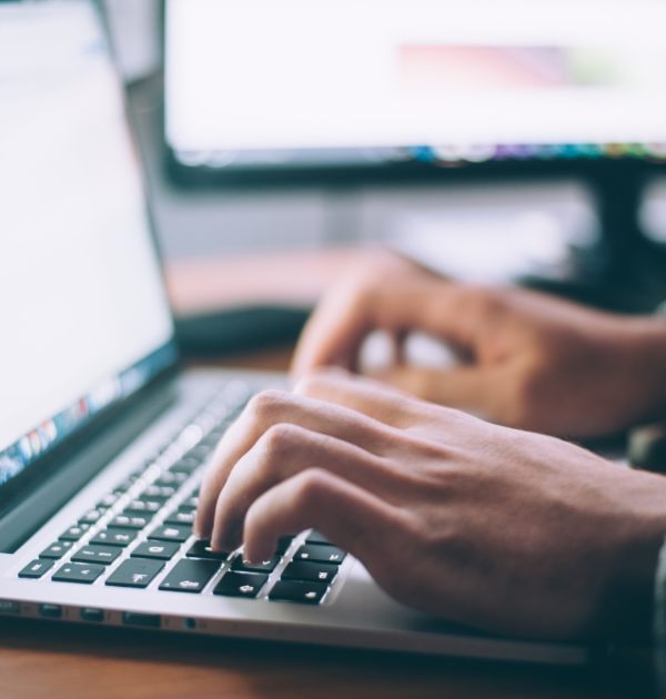 Man typing on a laptop representing research for search advertising
